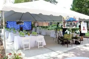 A white table and chairs set up for an outdoor event.