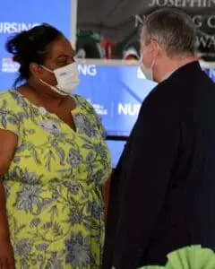 A woman wearing a face mask and a man in a suit