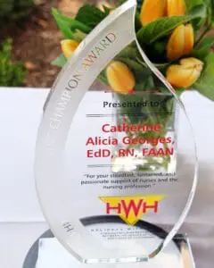 A glass award with flowers in the background.