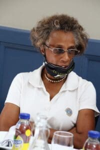 A woman with a mouth mask on sitting down.