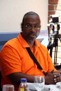 A man in an orange shirt is sitting down