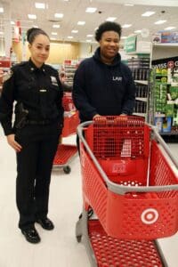 A man and woman standing in front of red shopping carts.