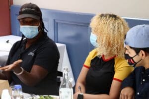 Two women wearing masks sit at a table.