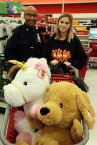 A woman and man standing next to stuffed animals.