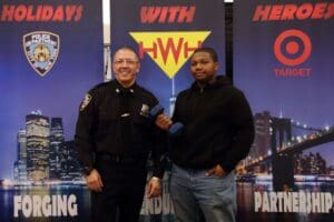 Two men standing in front of a sign with the word " hwh ".