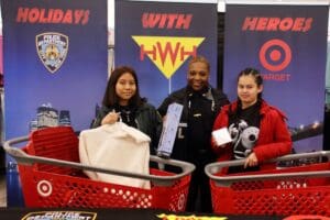 Three people standing in a store with shopping carts.