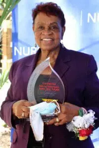 A woman holding an award in her hands.