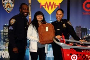 A woman holding a brown bag with two police officers standing next to her.