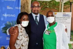 Three people wearing masks posing for a picture.